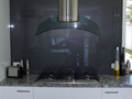 Stainless rangehood on glass splashback
